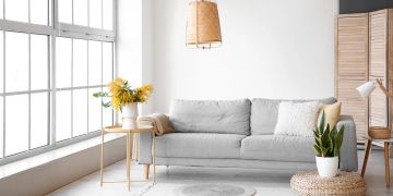 Helles Wohnzimmer mit Couch und Blumenstrauss
