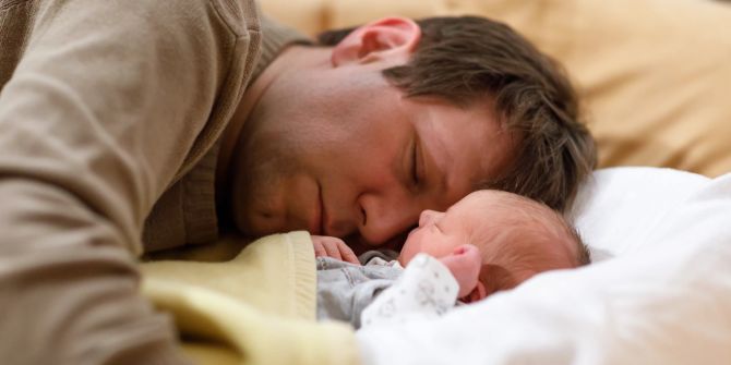 Schlafender Vater mit Neugeborenem