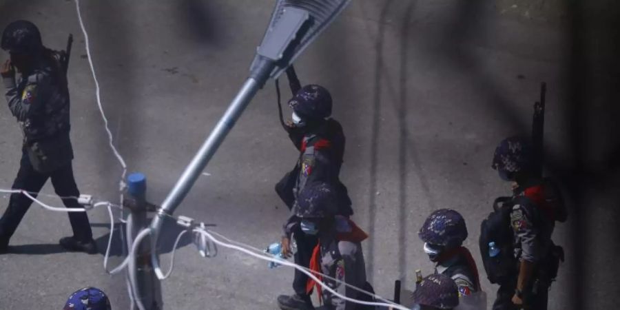 Polizisten patrouillieren schwer bewaffnet auf einer Strasse. Foto: Uncredited/AP/dpa