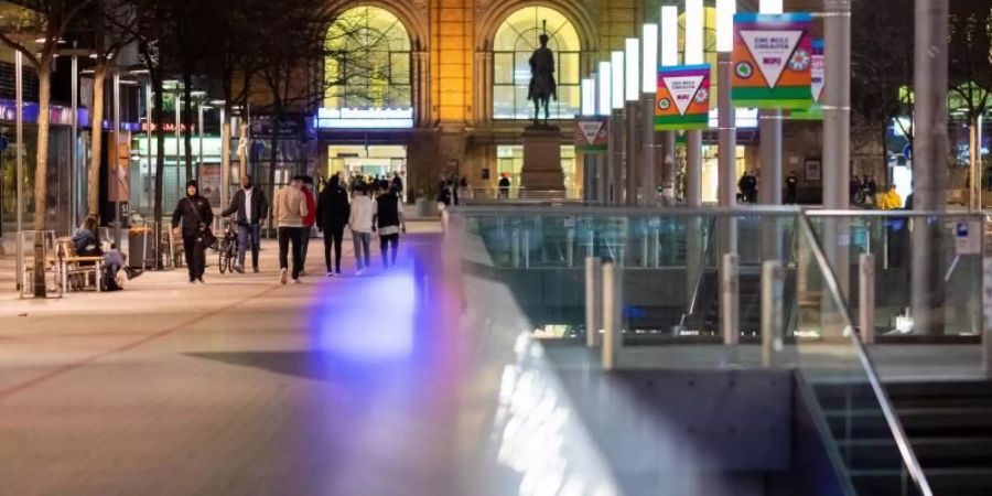 Passanten gehen am Abend durch die Innenstadt von Hannover. Foto: Moritz Frankenberg/dpa