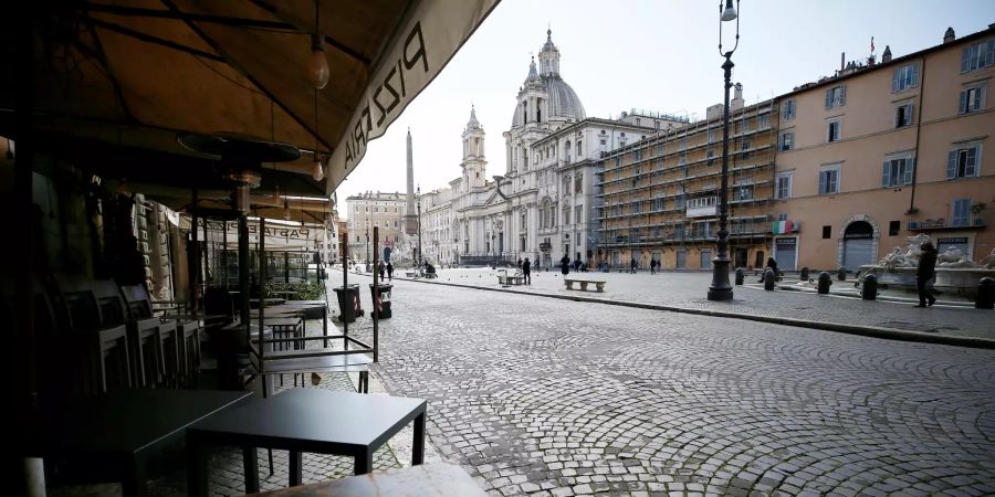 Italien, Rom: Stühle und Tische sind vor einem geschlossenen Restaurant auf dem Navona-Platz zusammengestellt.