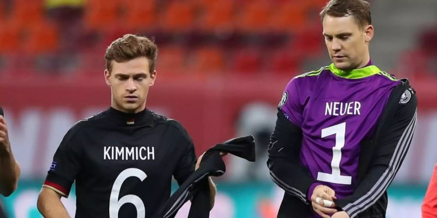 Deutschlands Joshua Kimmich (l) und Torwart Manuel Neuer tragen vor dem Spiel gegen Rumänien die Rückennummer auf der Brust. Foto: Stefan Constantin/dpa