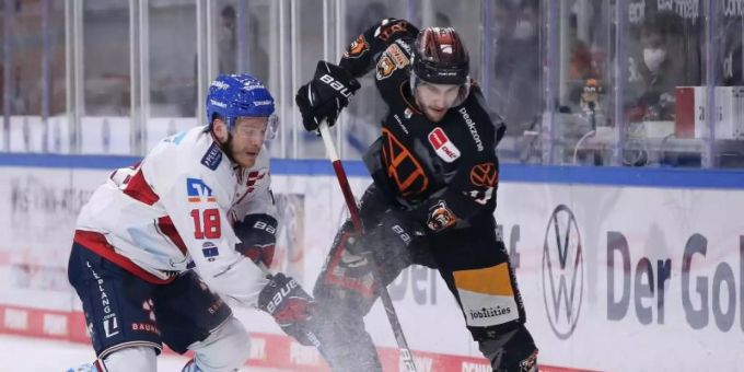 Der Wolfsburger Matti Järvinen (r) kämpft gegen den Mannheimer Ben Smith (l) um den Puck. Foto: Ronny Hartmann/dpa adler mannheim