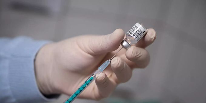ARCHIV - Ein Arzt zieht in einer Hausarztpraxis eine Spritze mit dem Impfstoff von Pfizer/Biontech auf. Foto: Sebastian Gollnow/dpa corona