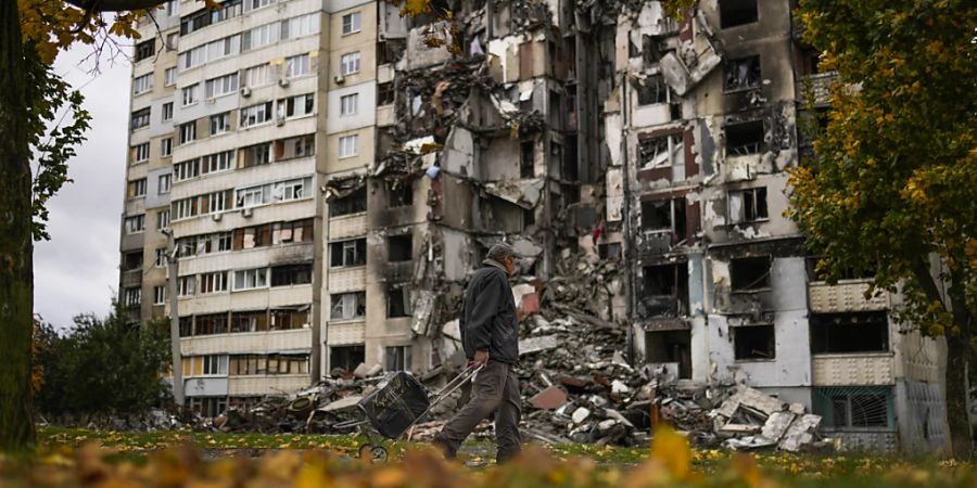 Ein Mann geht an einem teilweise zerstörten Wohnhaus im Stadtteil Saltiwka vorbei. Foto: Francisco Seco/AP/dpa