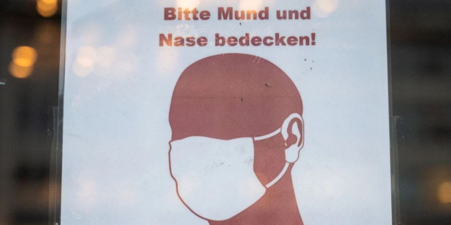 Ein Schild weist in Hamburg auf das Tragen einer Maske hin.
