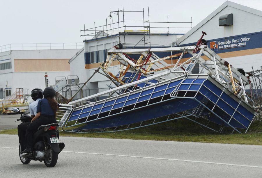 Ein Motorradfahrer fährt in St. George, Bermuda, an einem Gebäude vorbei, welches von dem Hurrikan «Fiona» zum Einsturz gebracht wurde.