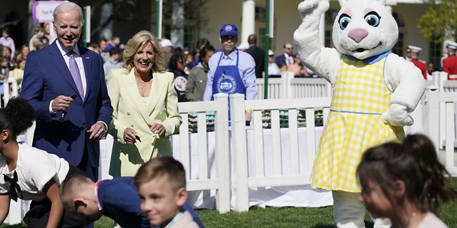 Joe Biden (hinten l), Präsident der USA und Jill Biden (hinten 2.v.l), First Lady der USA, nehmen am am traditionellen Ostereier-Rollen im Garten des Weissen Hauses teil. Tradition der Veranstaltung ist es, dass Kinder hartgekochte Eier mit langen Löffeln um die Wette über den Rasen rollen. Foto: Evan Vucci/AP/dpa