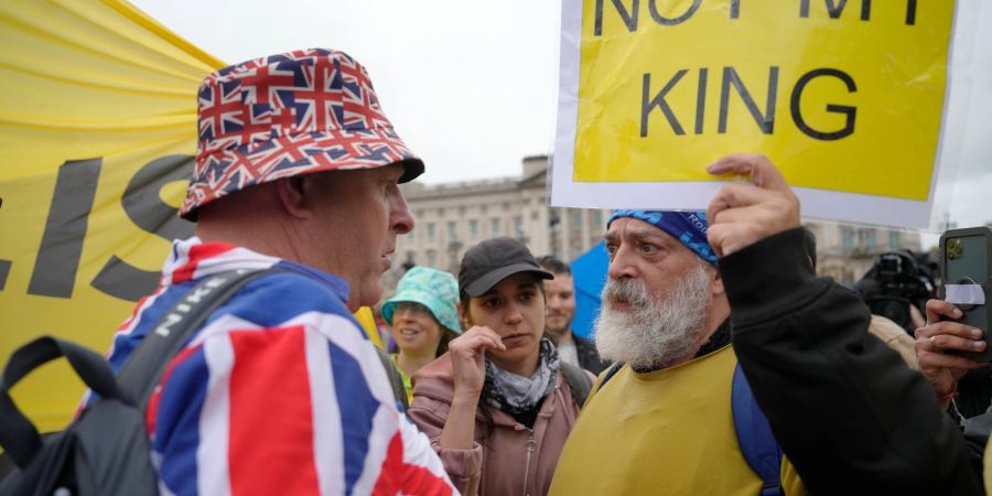 Ein Anti-Monarchie-Demonstrant (r), spricht mit einem Monarchie-Befürworter in der Nähe des Buckingham-Palastes.