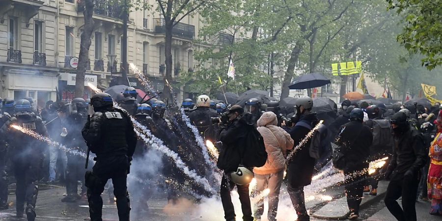 Seit Wochen protestieren Menschen aus ganz Frankreich gegen die geplante Rentenreform. Auch am 1. Mai gab es in Paris wieder Ausschreitungen....Ein Gegenstand explodiert zwischen Polizisten am Rande einer Demonstration am Tag der Arbeit. Französische Gewerkschaften planen Massendemonstrationen in ganz Frankreich, um gegen den jüngsten Vorstoss von Präsident Macron zu protestieren, das Renteneintrittsalter von 62 auf 64 Jahre anzuheben. Foto: Thibault Camus/AP/dpa