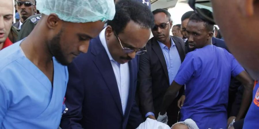 Somalias Präsident Mohamed Abdullahi Mohamed (Mitte l) besucht Opfer, die bei der Explosion einer Autobombe am 28.12.2019 verletzt wurden. Foto: Farah Abdi Warsameh/AP/dpa