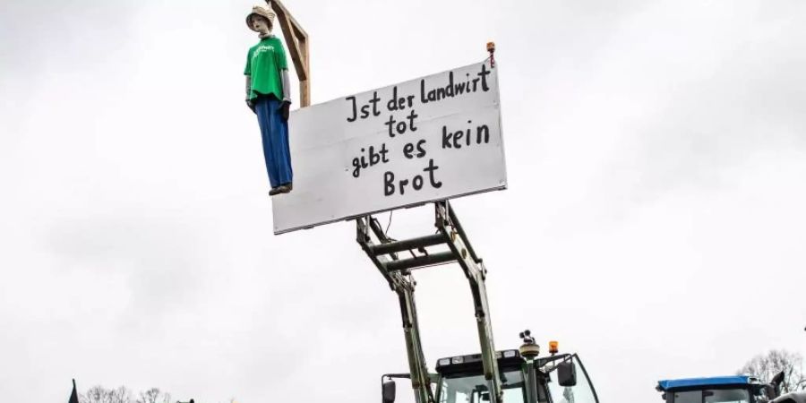 Eine Puppe hängt an einem Traktor und baumelt an einem Galgen mit dem Schild: "Ist der Landwirt tot gibt es kein Brot". Foto: Guido Kirchner/dpa/Archiv