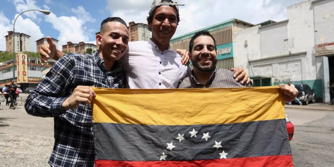 Hebert Ramirez (r) und Yorman Ortiz (l) halten eine Flagge von Venezuela und lächeln, nachdem sie aus der Haft entlassen wurden. UN-menschenrechtsrat