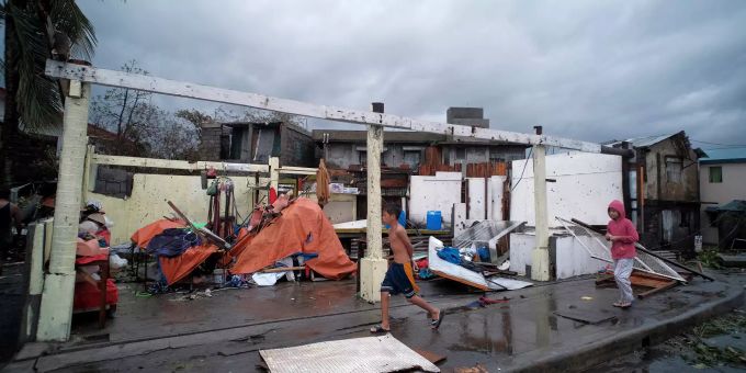 Philippinen Taifun: Kinder gehen an den Trümmern von Häusern vorbei, die durch den Taifun «Kammuri» in den Philippinen stark beschädigt wurden. Philippinen Taifun
