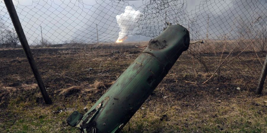 Der Teil einer Rakete liegt auf dem Boden vor einem brennenden Munitionslager in der Nähe der ostukrainischen Stadt Balaklija (Ukraine).