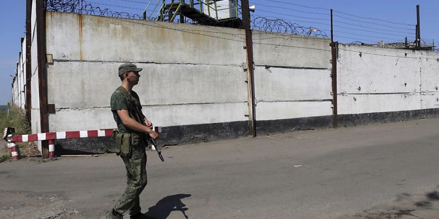 Ein Soldat steht am Freitag Wache neben der Mauer eines Gefängnisses in Oleniwka, in einem von den von Russland unterstützten Separatisten kontrollierten Gebiet. Foto: -/AP/dpa