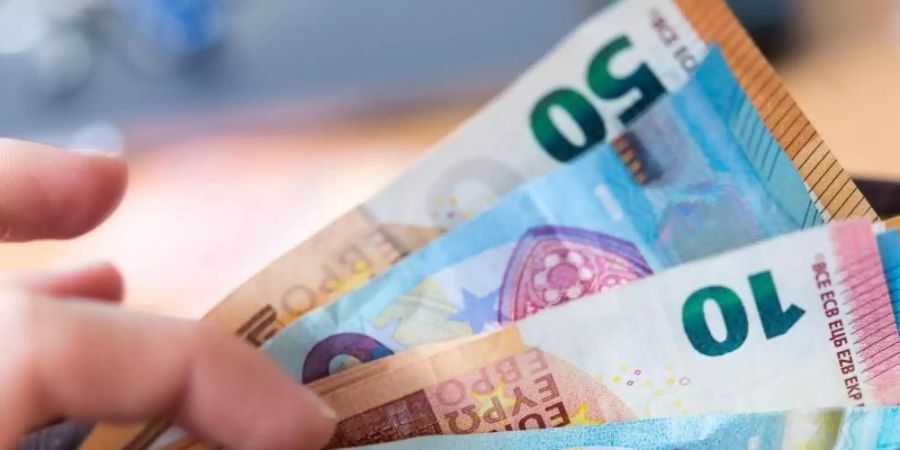 Eine Frau hält eine Geldbörse mit Banknoten in der Hand. Foto: Monika Skolimowska/dpa-Zentralbild/dpa