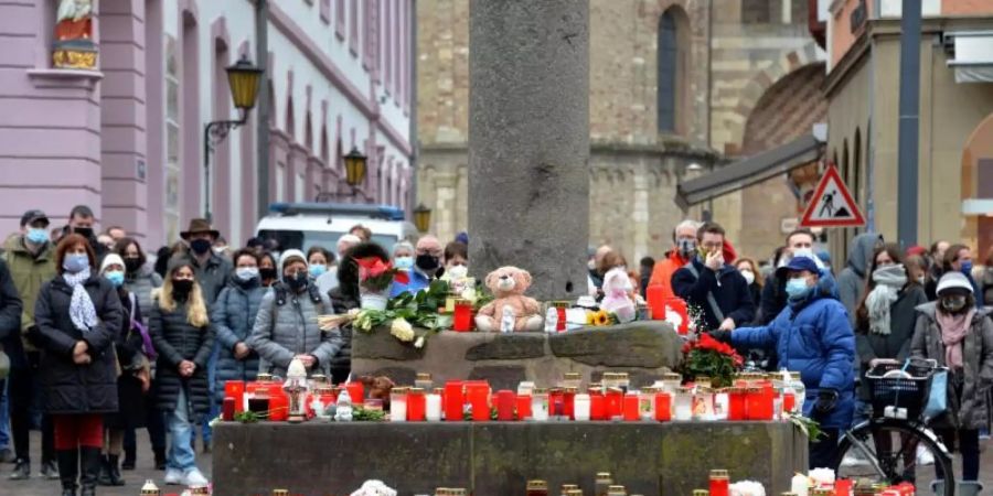 Menschen stehen bei einer Schweigeminute zum Gedenken der Opfer nach der Amokfahrt von Trier mit Toten und Verletzten um genau die Uhrzeit, zu der ein 51-jähriger Mann am Dienstag durch die Fussgängerzone gerast ist. In ganz Trier läuteten die Kirchenglocken. Foto: Harald Tittel/dpa