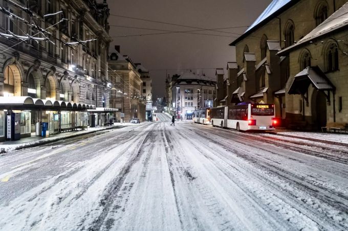 Ein Passant geht über eine verschneite Strasse auf dem Place St-Francois in Lausanne VD. schweizerische bundesbahn