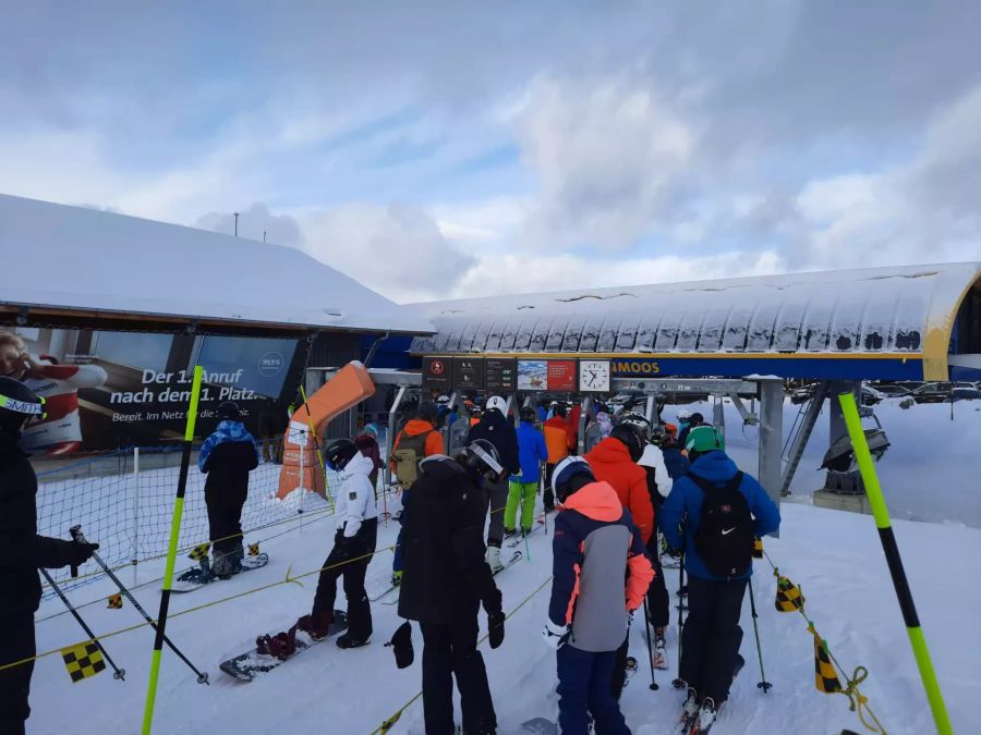 Die Skifahrer tragen Masken und halten den Abstand zum Schutz vor dem Coronavirus ein.