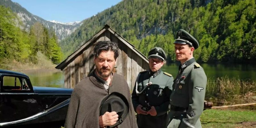 Sepp Rottenbacher (l, Fritz Karl) muss Kaltenbrunner (r, Oliver Masucci) und Schädler (M, George Lenz) auf den See rudern. Foto: Bernd Schuller/ZDF/dpa