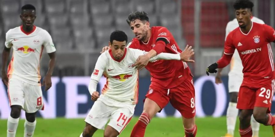 Leipzigs Tyler Adams (2.vl) und Münchens Javi Martinez kämpfen um den Ball - nach 25 Spielminuten war für den Bayern verletzungsbedingt Schluss. Foto: Sven Hoppe/dpa