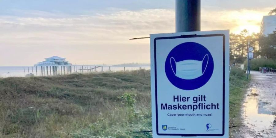 Hinweis auf die Maskenpflicht in Timmendorfer in Schleswig-Holstein Strand. Foto: Thomas Müller/dpa