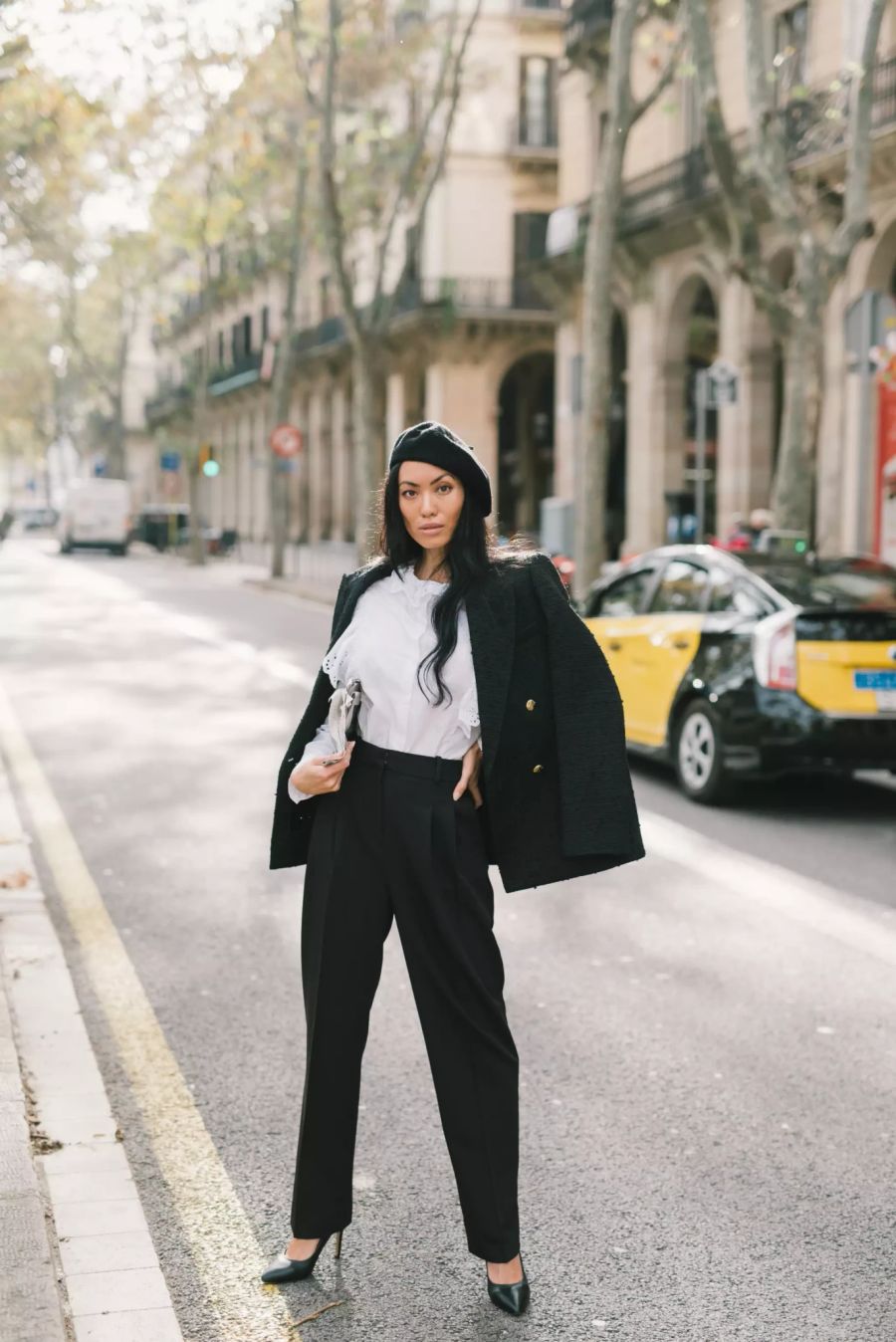 Asiatische Frau im Business Look auf einer Seitenstrasse.