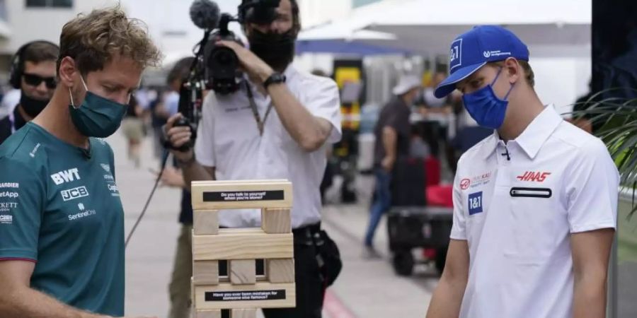 Duell der anderen Art in Austin: Sebastian Vettel (l) und Mick Schumacher spielen Jenga. Foto: Darron Cummings/AP/dpa