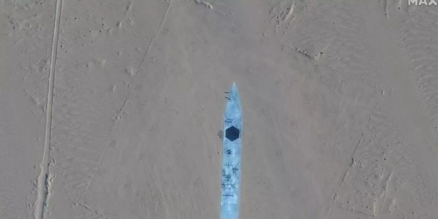 Das Satellitenbild zeigt die Nachbildung eines Flugzeugträgers in der Taklamakan-Wüste. Foto: Uncredited/Maxar Technologies/AP/dpa