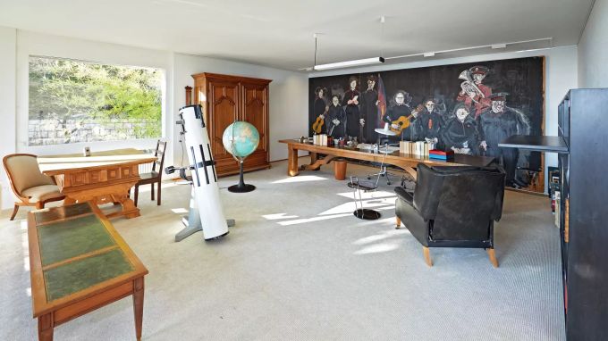 Ein Blick in das Arbeitszimmer Dürrenmatts. Auffallend das Teleskop des astronomisch interessierten Dichters und der ausserordentlich lange Tisch: Hier lagen der Legende nach immer zwei Stapel Blätter, die einen zum Malen und Zeichnen, die anderen zum Schreiben. s