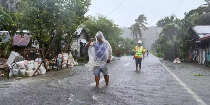 Bewohner waten durch eine vom Taifun «Rai» überflutete Strasse auf den Philippinen. Foto: Alren Beronio/AP/dpa taifun rai