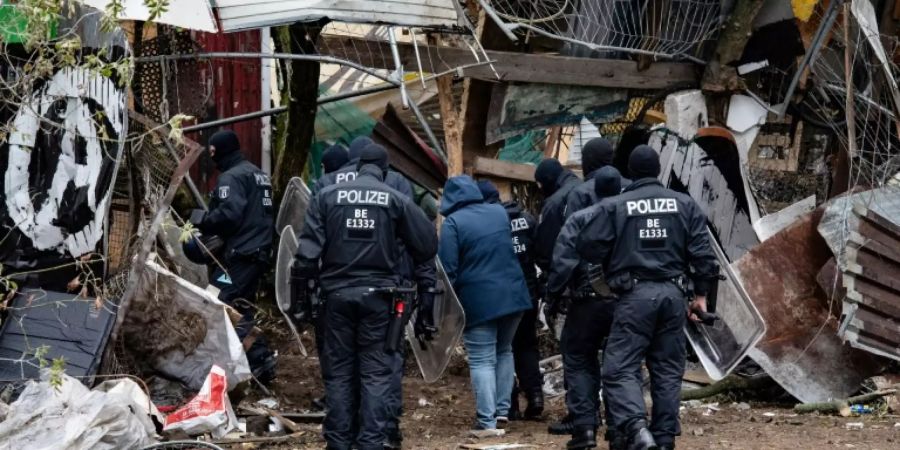 Polizisten an dem Zaun um den Bauwagenplatz