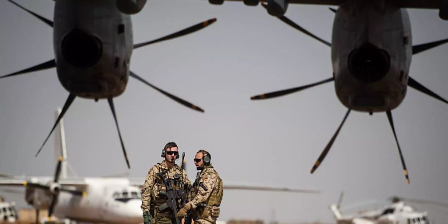ARCHIV - Deutsche Soldaten stehen am Flughafen in Gao und sichern ein Transportflugzeug. Foto: Arne Immanuel Bänsch/dpa