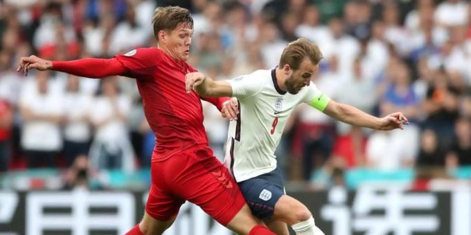 Dänemarks Jannik Vestergaard (l) und Englands Harry Kane kämpfen um den Ball - im Hintergrund eine chinesische Bandenwerbung. Foto: Nick Potts/PA Wire/dpa Dänemarks Jannik Vestergaard (l) und Englands Harry Kane kämpfen um den Ball - im Hintergrund eine chinesische Bandenwerbung. Foto: Nick Potts/PA Wire/dpa