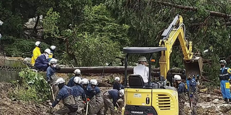 Auf diesem Foto, das von der Nagasaki Kenou Wide Area Fire Department zur Verfügung gestellt wurde, suchen Feuerwehrleute nach schweren Regenfällen in einem Gebiet im Obama-Viertel von Unzen, Präfektur Nagasaki, Südjapan, nach vermissten Personen. Foto: Nagasaki Kenou Wide Area FD/via AP/dpa