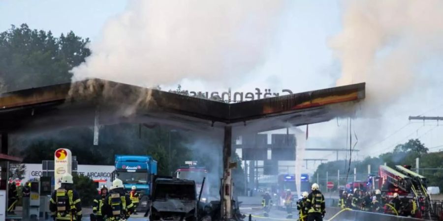 Löscharbeiten an der Autobahn-Tankstelle. Am Montag raste ein Fahrzeug mit über 150 km/h in die Anlage. Foto: Skander Essadi/5vision.media/dpa