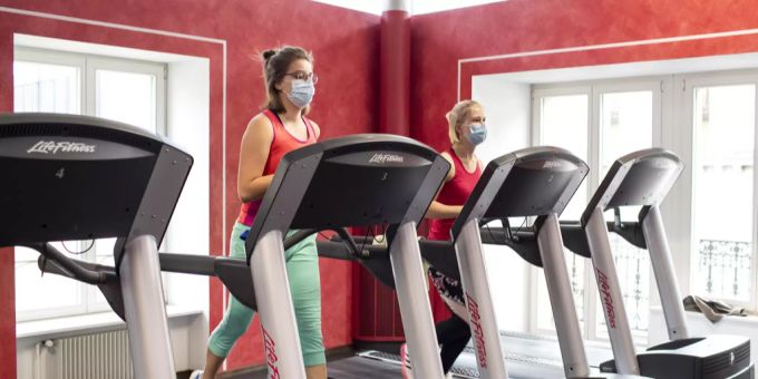 Menschen trainieren mit Maske in einem Fitnesscenter. (Symbolbild) Fitnesscenter