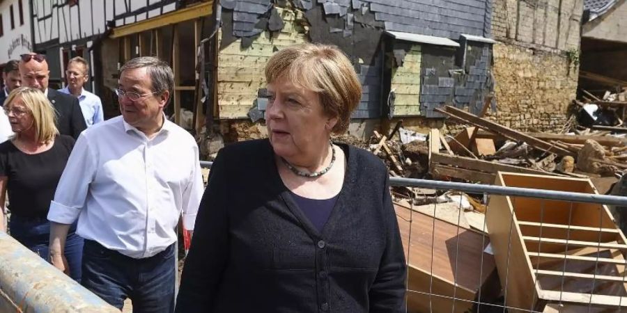 Bundeskanzlerin Angela Merkel und NRW- Ministerpräsident Armin Laschet (2.v.r), im vom Hochwasser betroffenen Stadtteil Iversheim. Foto: Wolfgang Rattay/Reuters/dpa