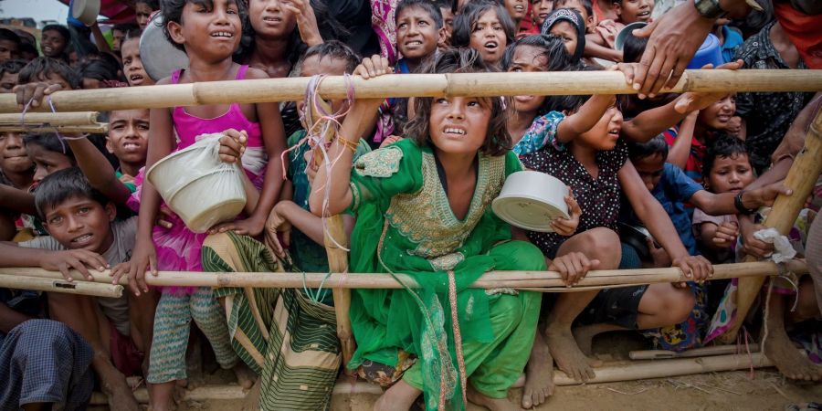 Aus Myanmar vertriebene Kinder der Rohingya warten in einem Flüchtlingslager in Bangladesch auf Nahrungsmittel.