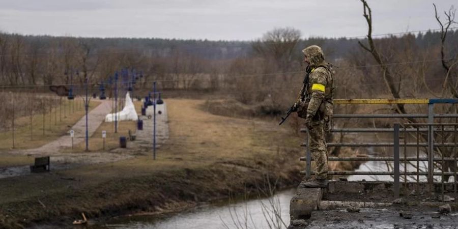 Ein ukrainischer Soldat im Ukraine-Krieg in der Nähe einer zerstörten Brücke am Fluss Irpin.