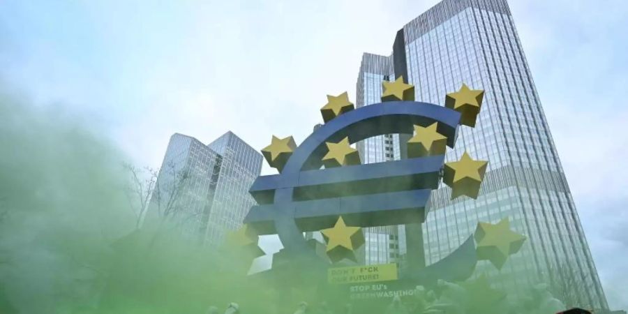 Aktivisten des «Koala Kollektivs» demonstrieren vor der Euro-Skulptur in der Frankfurter Innenstadt gegen «Greenwashing» von Atomenergie und Erdgas durch die Taxonomie der EU. Foto: Arne Dedert/dpa