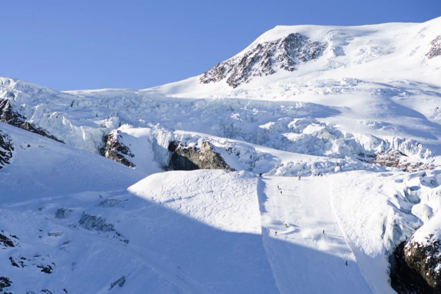 Skifahrer und Snowboarder auf der Piste in Saas-Fee.
