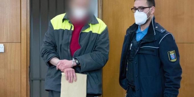 Der Angeklagte und mutmassliche Verfasser der „NSU 2.0“-Drohschreiben wird mit Handschellen in den Verhandlungssaal geführt. Foto: Boris Roessler/dpa Pool/dpa Der Angeklagte und mutmassliche Verfasser der „NSU 2.0“-Drohschreiben wird mit Handschellen in den Verhandlungssaal geführt. Foto: Boris Roessler/dpa Pool/dpa