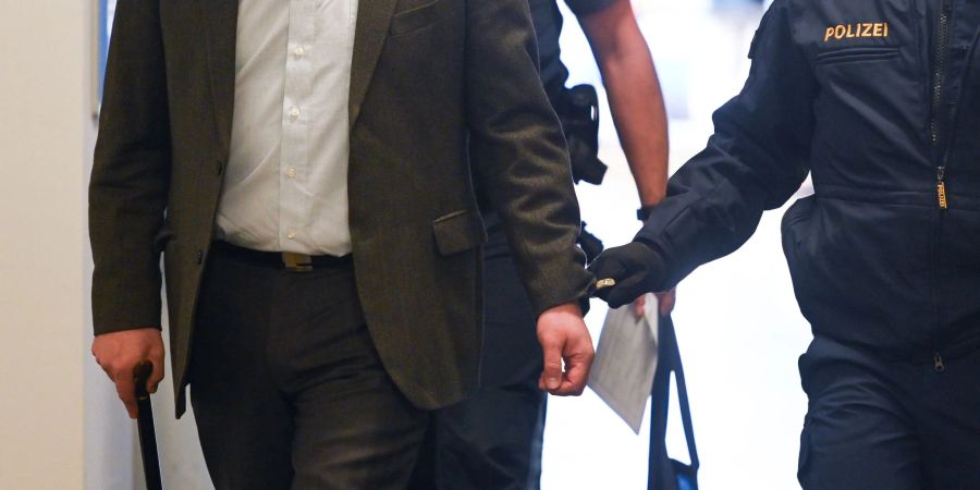 Der Angeklagte (v.l.) wird kurz vor Prozessauftakt Anfang Februar von Polizisten in das Landgericht Traunstein gebracht.