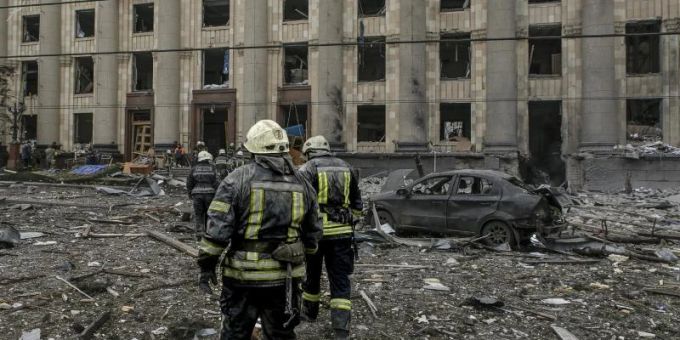 Ukrainische Rettungskräfte arbeiten vor dem beschädigten Rathausgebäude in Charkiw nach dem russischen Beschuss. Ukraine-Krieg