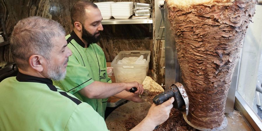 Halit (l) und Halip vom Imren Grill in Berlin bereiten einen Döner zu. Vor fünfzig Jahren soll er erfunden worden sein.