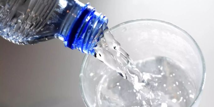 Ein Glas wird mit Wasser gefüllt Ein Glas wird mit Wasser gefüllt