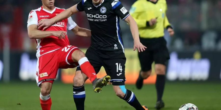 Berlins Manuel Schmiedebach (l) kämpft gegen Joan Simun Edmundsson von Arminia Bielefeld um den Ball. Foto: Andreas Gora