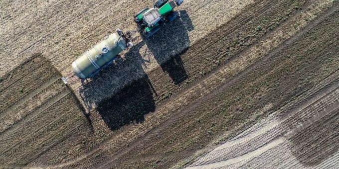 Landwirt beim Düngen eines Feldes Landwirt beim Düngen eines Feldes